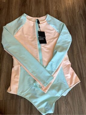 Hurley women’s Long-Sleeve One-Piece in Mint & Peach bathing suit.